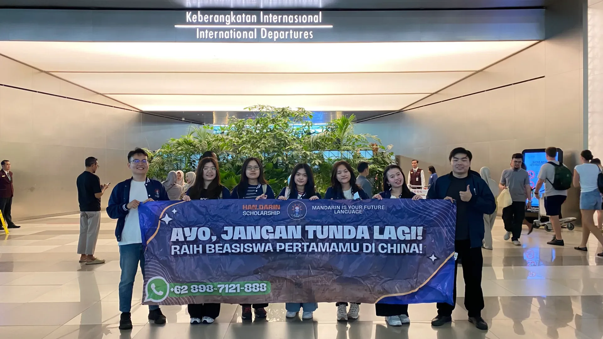 Sekelompok murid berfoto bersama di bandara sebelum berangkat dengan koper.